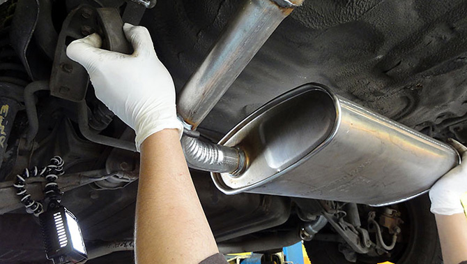 mechanic performing a exhaust fitting and service